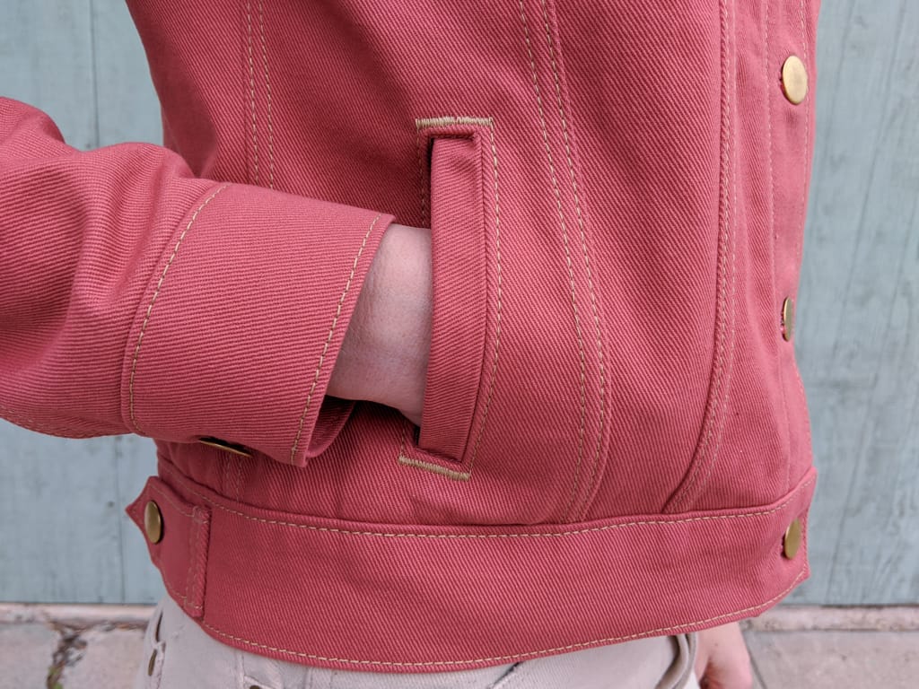 Pink denim jacket, welt pocket close up