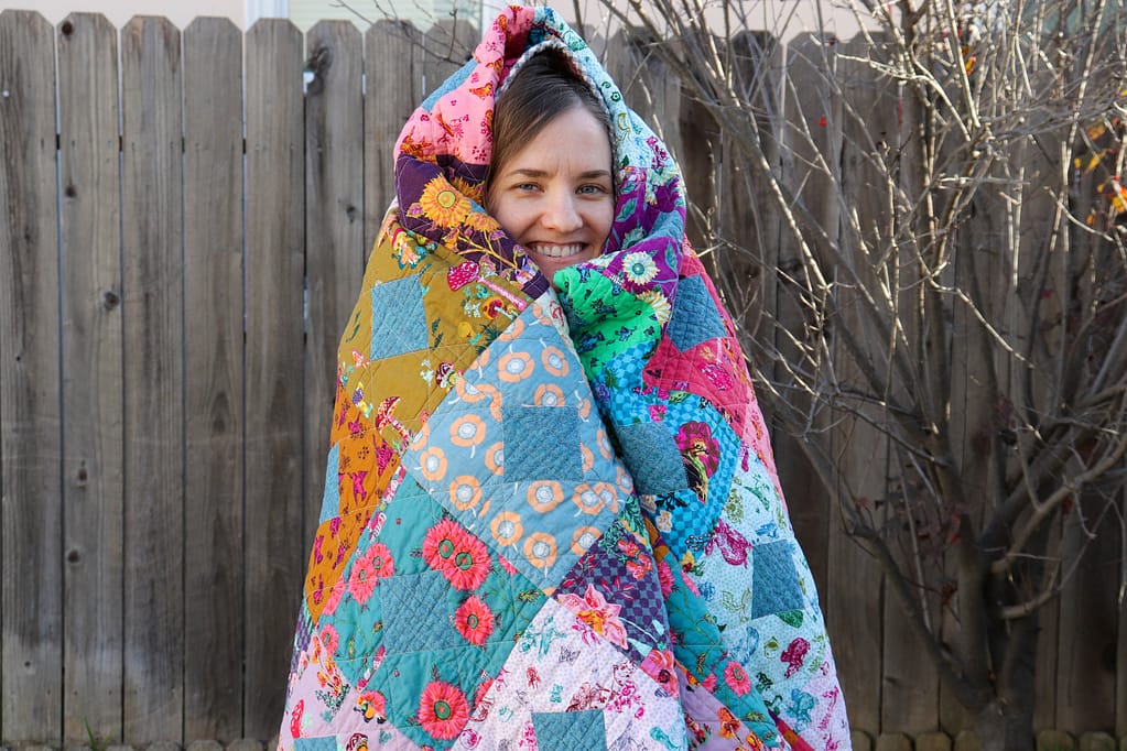 Miranda wrapped in her completed Diamond and Squares quilt.